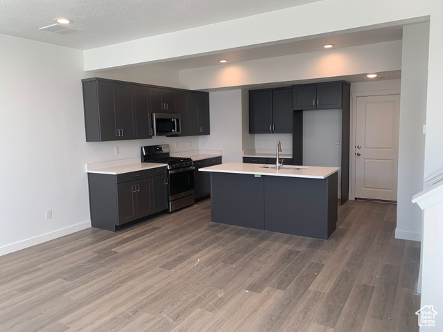 Kitchen with dark cabinets, an island, and adjoining living area at 11184 S Haviture Road